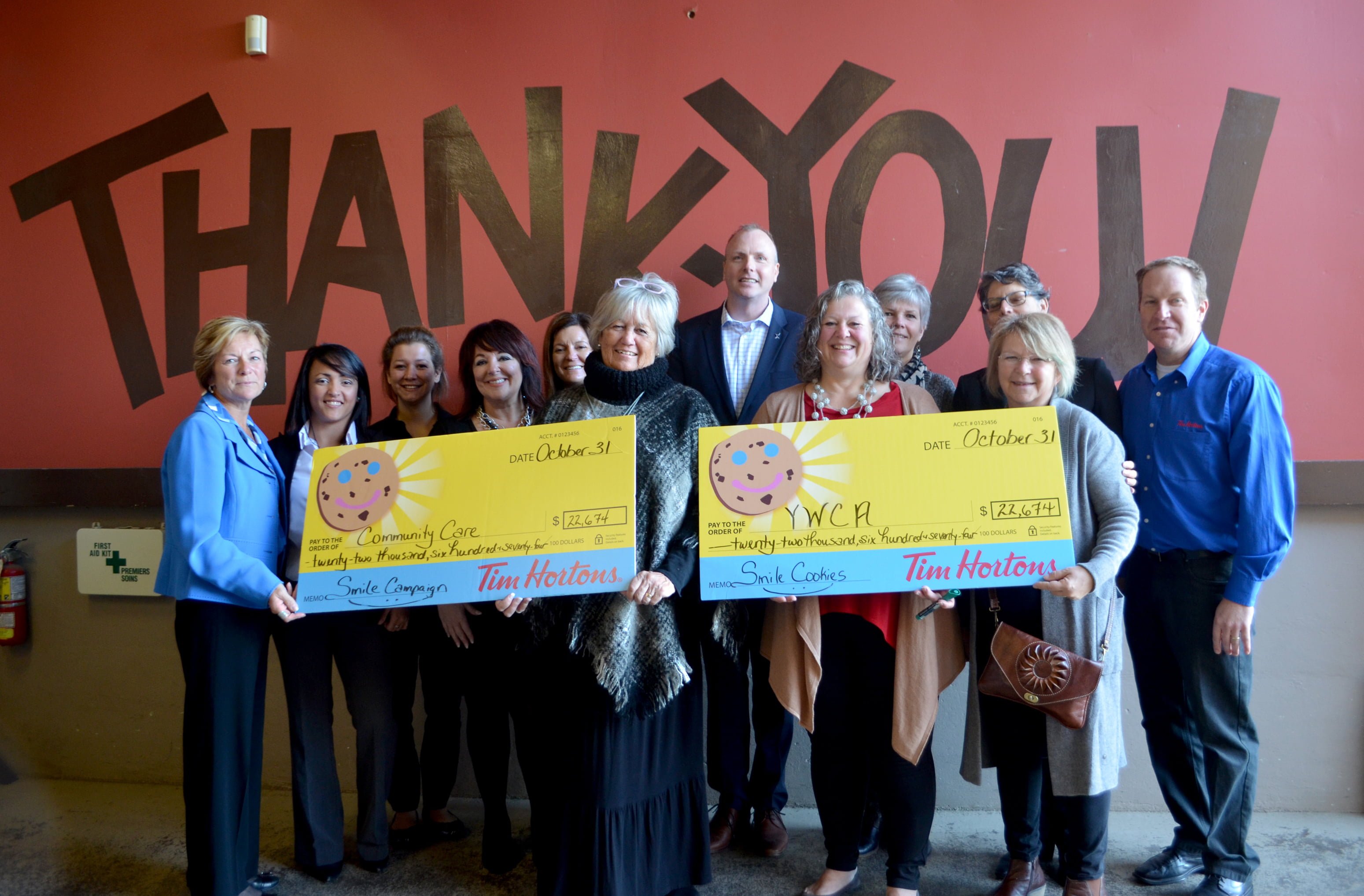 Tim Horton Franchise owners presenting the cheque for the proceeds from the Smile Cookie Campaign. Receiving the cheque are board members from both charities; CEO Betty Lou Souter of Community Care; Executive Director Elisabeth Zimmerman from the YWCA; Laura Byers, Fund Development Officer, Community Care; Nicki Inch, Fund Developer, YWCA.