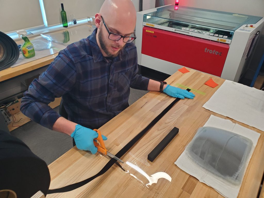 Research assistant Tyler Winger (an NC electrical Engineering Technology graduate) assembles face shields inside Niagara College’s Walker Advanced Manufacturing Innovation Centre to meet the need for critical health supplies.