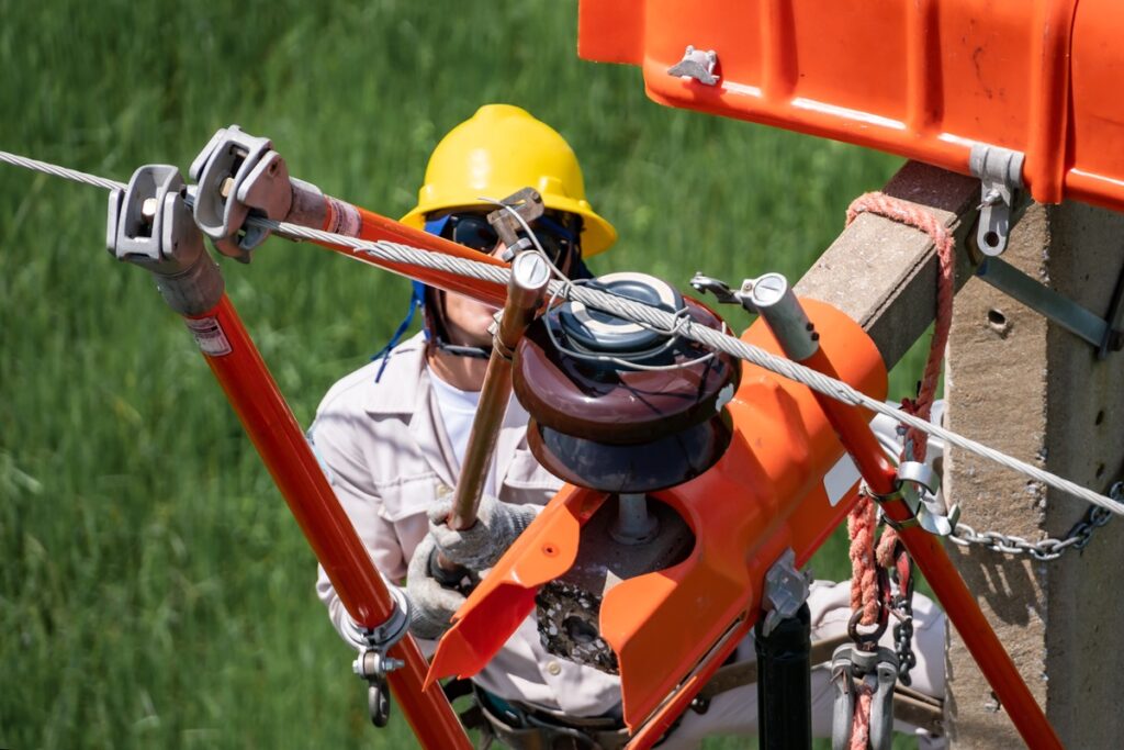 A linesman works on a municipal electricity pole.