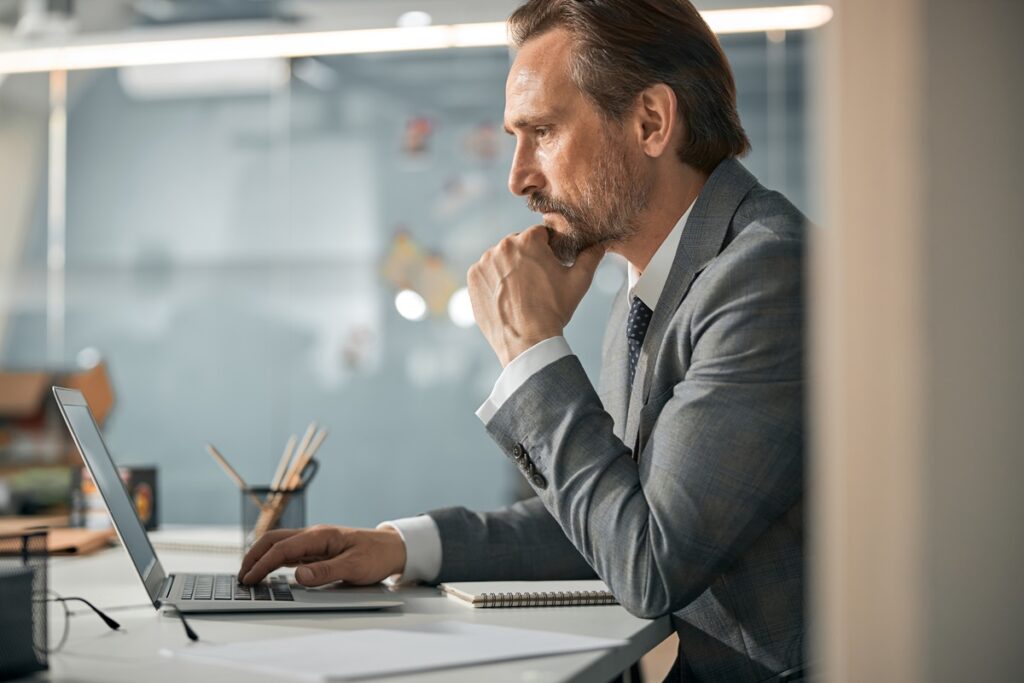 A man in a suit working looking concerned