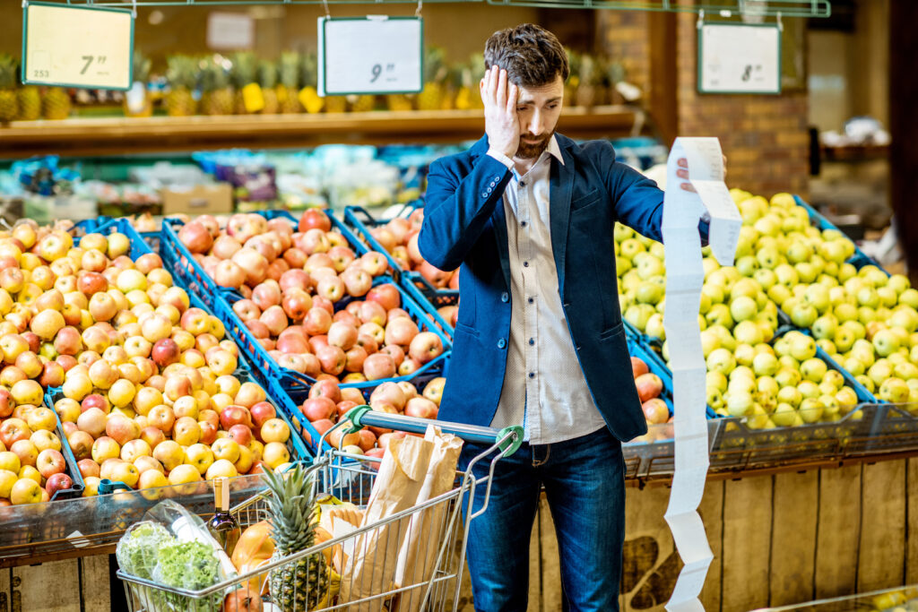 A man stares in shock at a grocery bill