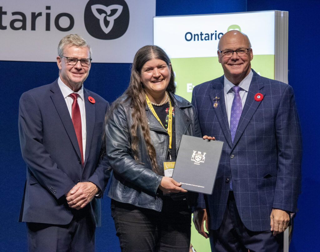 Amy Proulx (centre) is recognized with an Honorable Mention in Education Excellence by Minister of Agriculture, Food and Agribusiness Rob Flack (right), and Member of Provincial Parliament for Lanark – Frontenac – Kingston, and Parliamentary Assistant to the Minister of OMAFA, John Jordan (left).