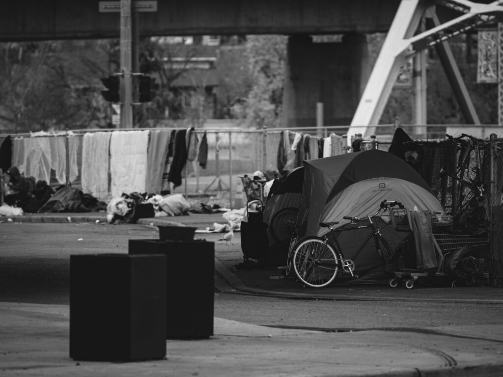 A black-and-white photograph of a homeless encampment in Calgary, Alberta