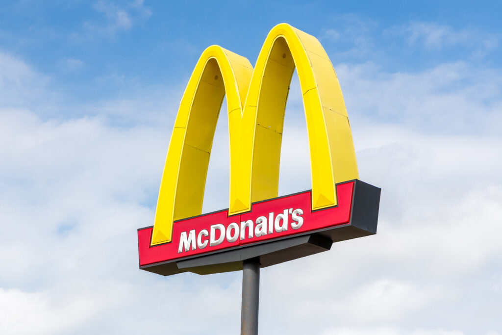 The McDonald's "golden arches" logo against a blue sky