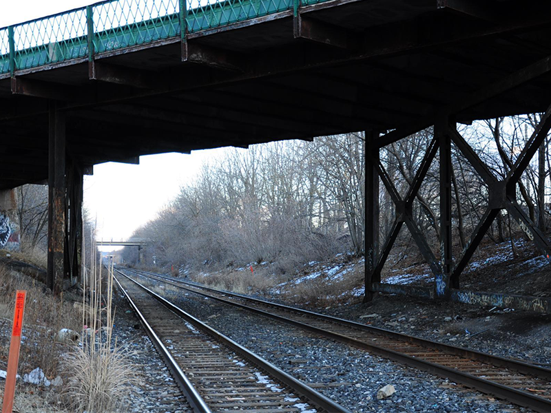 A view along the train tracks under the St. Paul Street West bridge