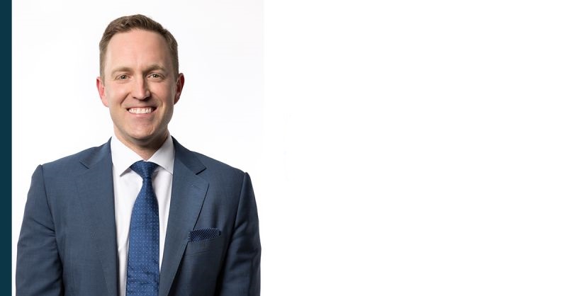 Michael Lindsay, a smiling White man wearing a blue suit and blue tie.