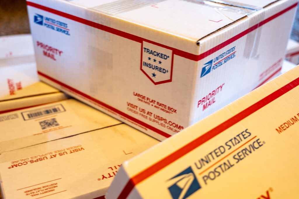 A stack of United States Postal Service shipping boxes