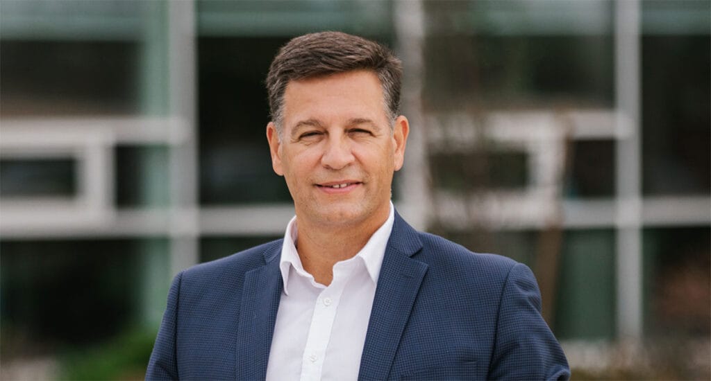 Niagara Region Director of Economic Development George Spezza. A White man with brown hair wearing a blue suit and white dress shirt with no tie.