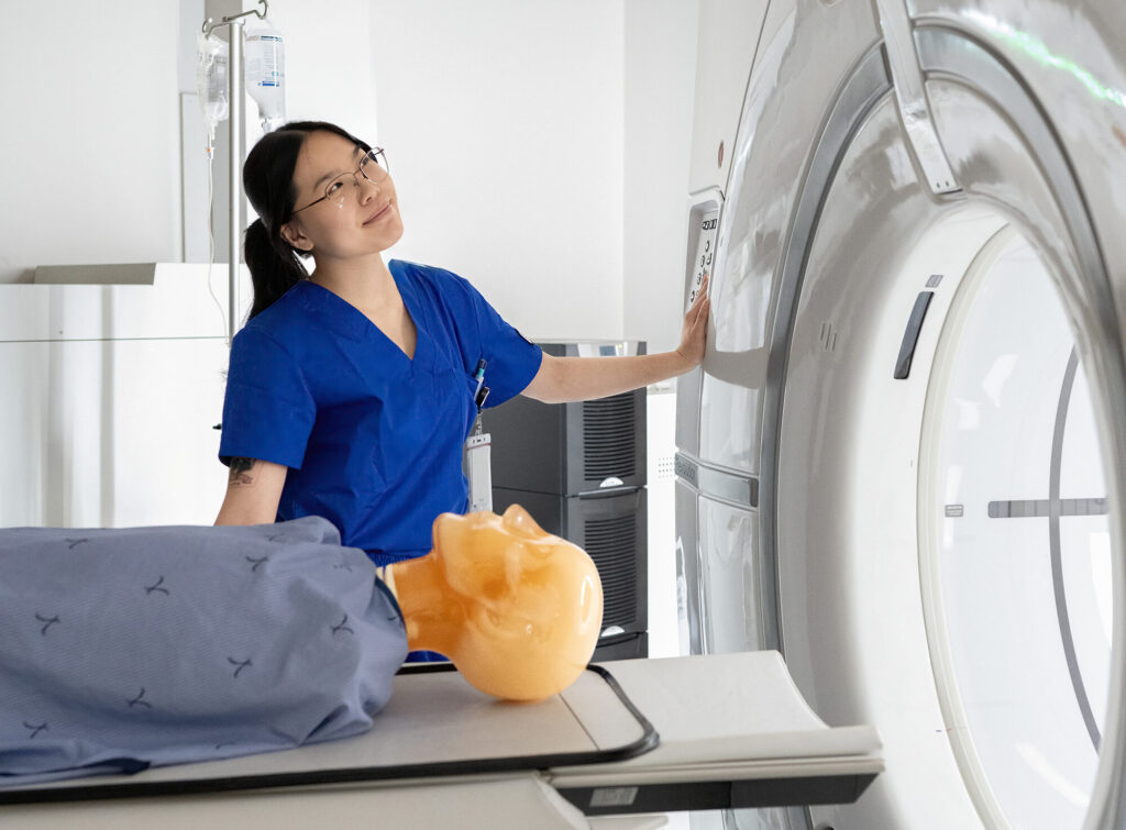 Mohawk College Medical Radiation Sciences student Han Nguyen practices with a CT scanner on a medical manikin.