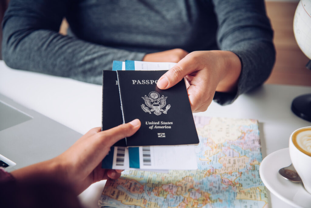 A man hands a U.S. passport over to an official