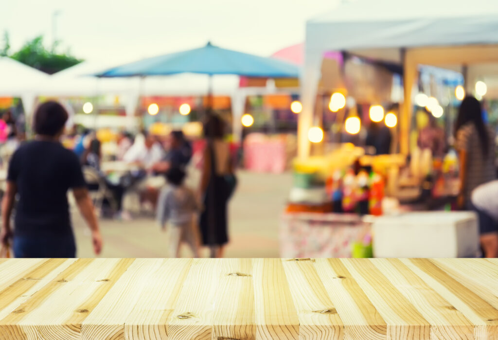A view from behind a stall table on to a busy open-air market