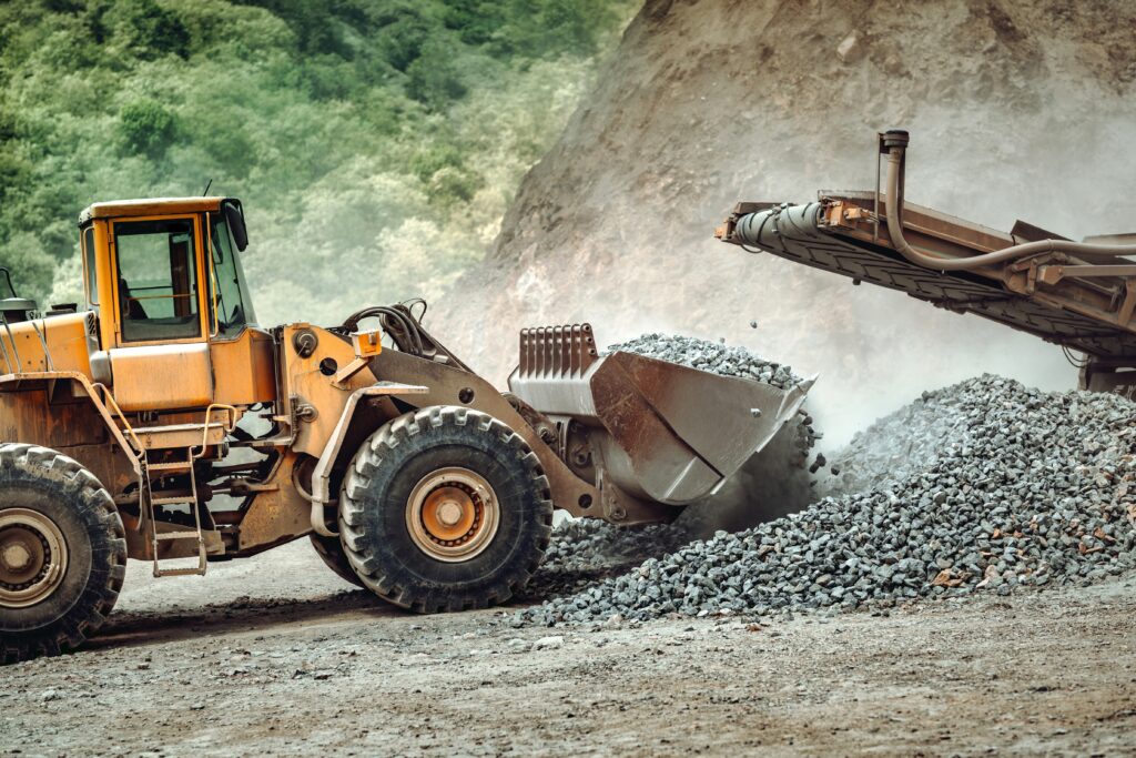 Industrial wheel loader working on site. Close up of wheel loader working, unloading gravel