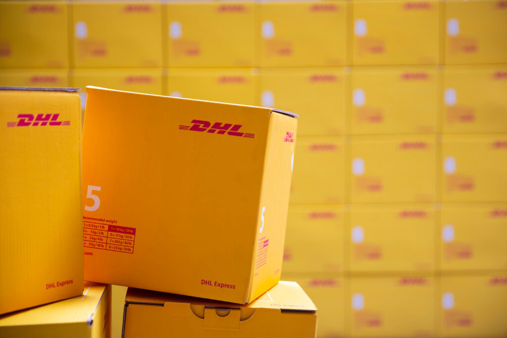 Yellow DHL Express packages are seen arranged in a warehouse.