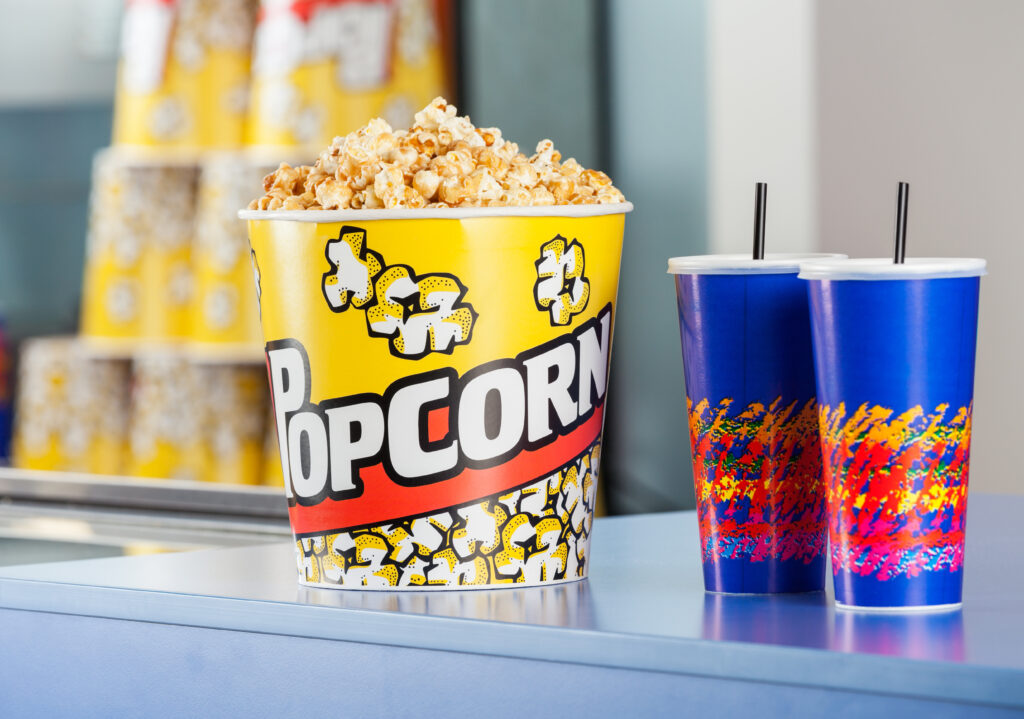 Popcorn bucket with cold drinks on concession counter at cinema