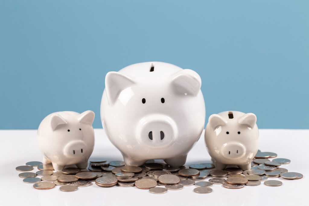 Family piggy bank, white ceramic piggy bank on stack coins on white wood table